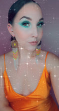 Load image into Gallery viewer, Modeling large, silver concho earrings with dangling beading in yellow, hot pink, orange and turquoise with chain fringe