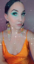 Load image into Gallery viewer, Modeling large, silver concho earrings with dangling beading in yellow, hot pink, orange and turquoise with chain fringe
