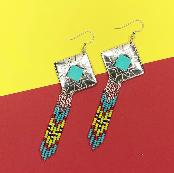 Diamond shaped silver concho with turquoise, red, yellow and green dangling bead work on fishhooks